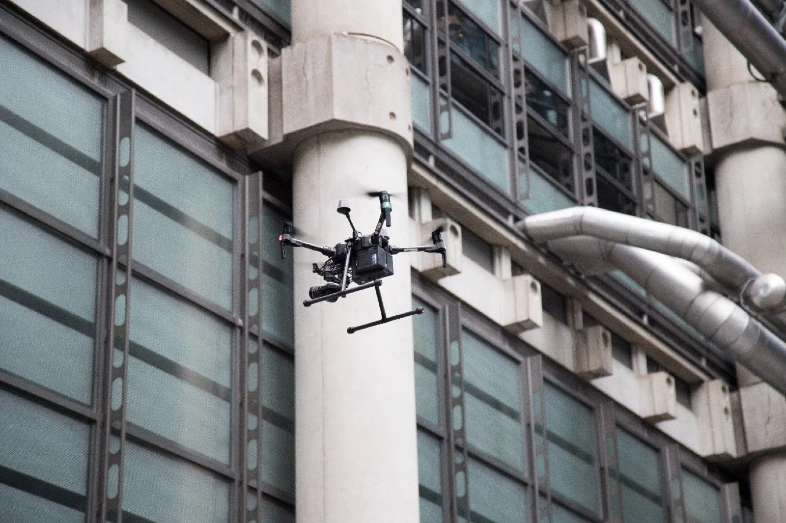 Drone flying close to a building during a roof inspection