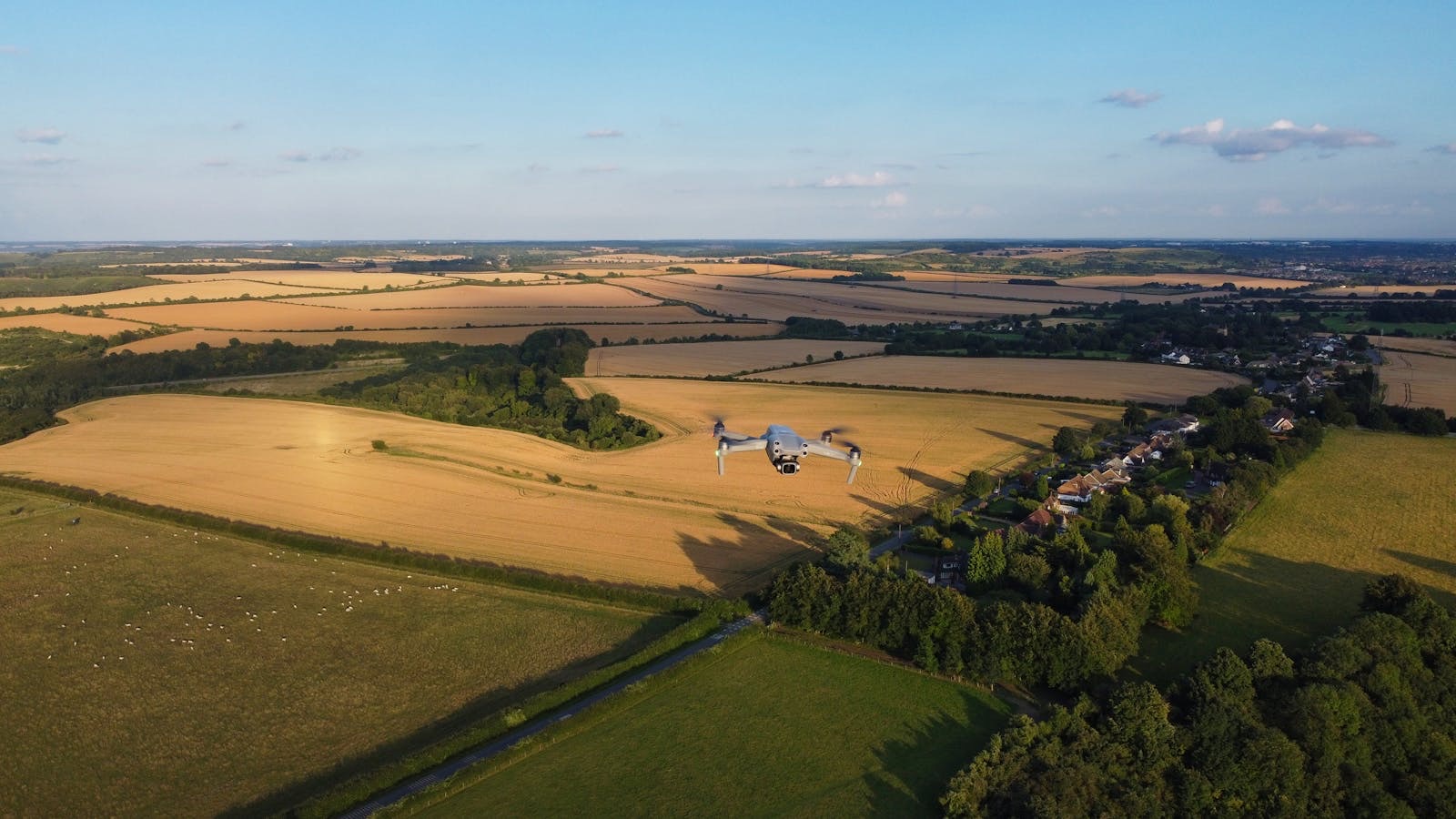 Aerial drone view of open green farmland and fields