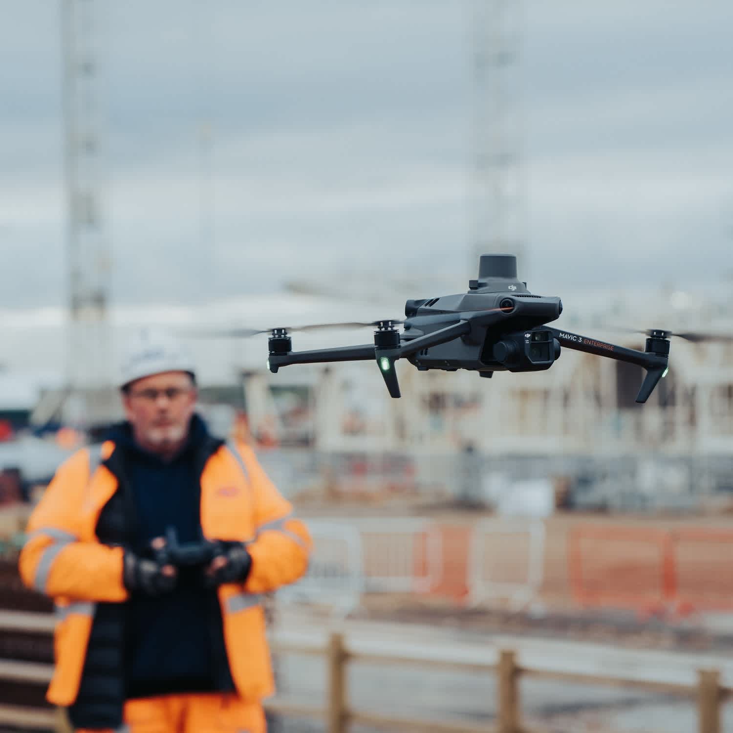 Drone pilot in hi-vis operating a Mavic 3 Enterprise over a construction site in Cyprus