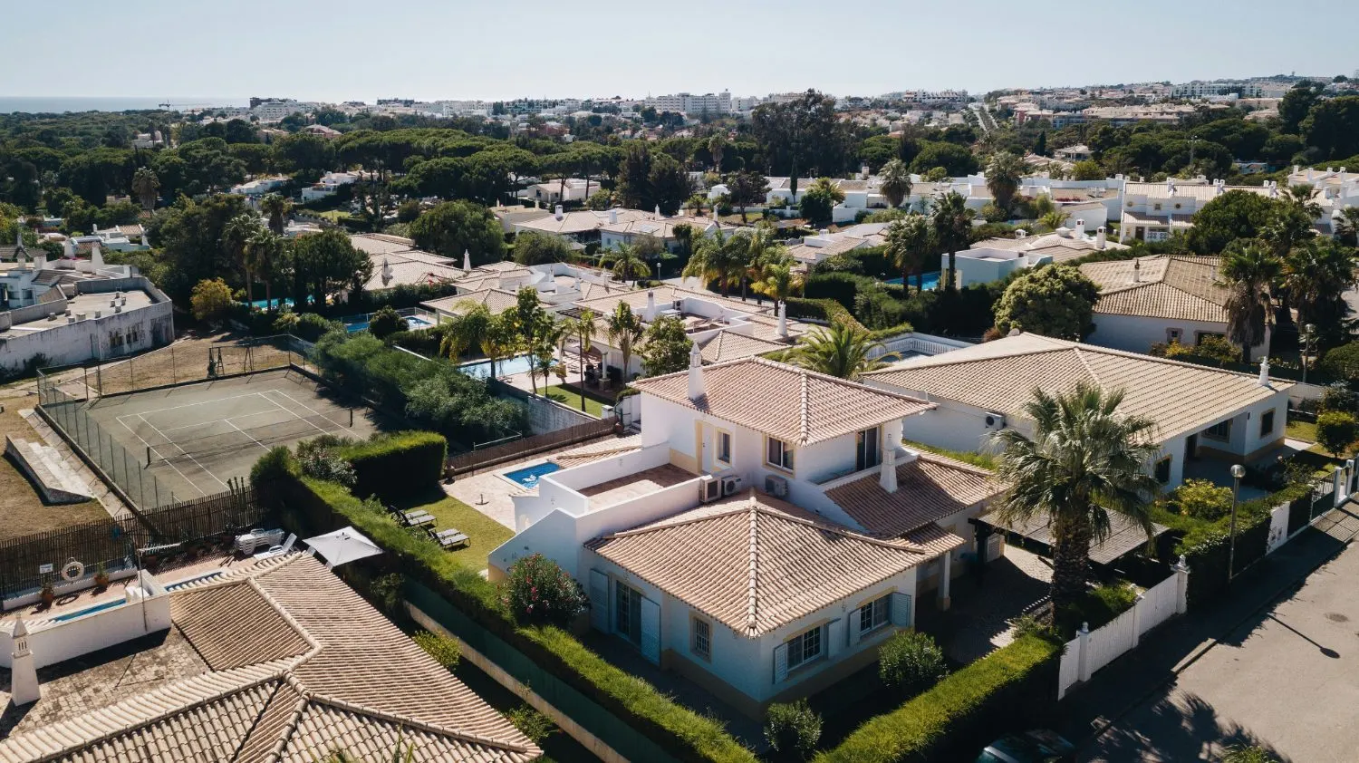 Aerial view of a Cyprus-style villa with pool and tennis court