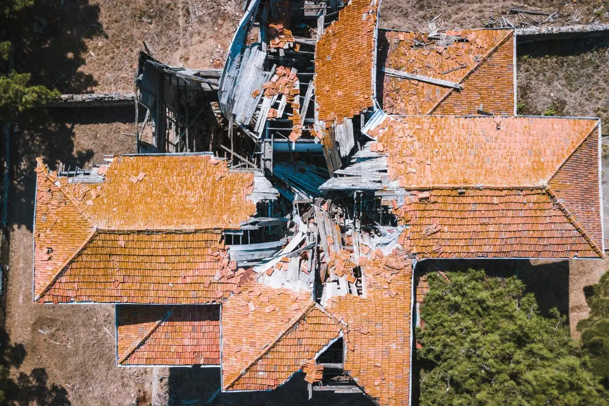 Top-down drone view of a collapsed tiled roof with structural damage